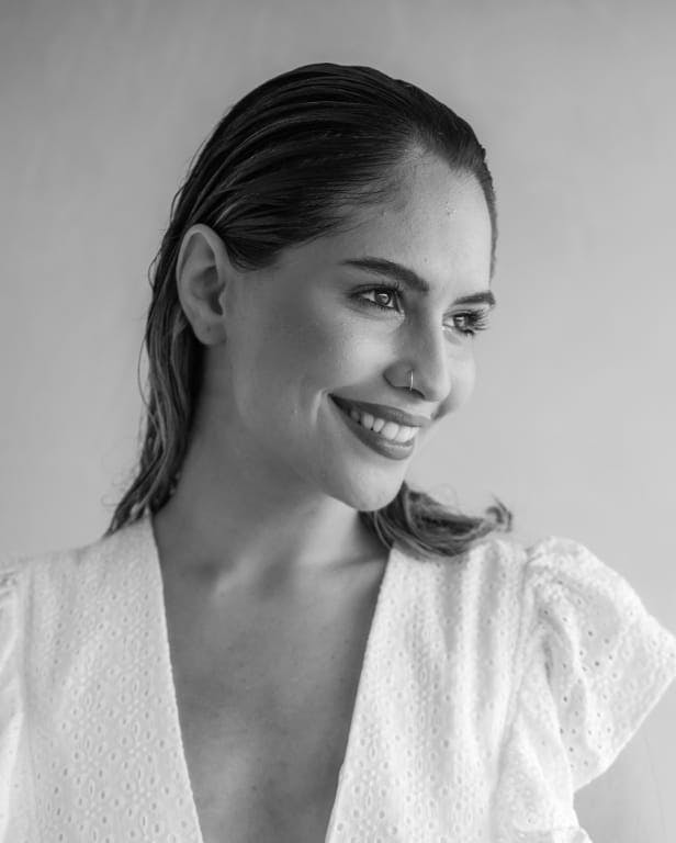 a smiling woman with nose ring and hair slicked back