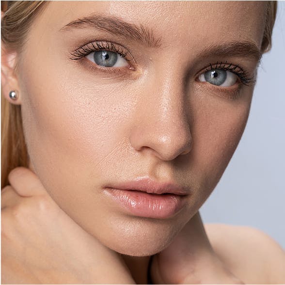Close-up of a woman's face, with her hands to her neck