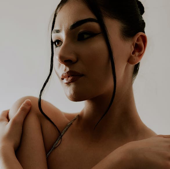 Woman with her hands against her shoulders