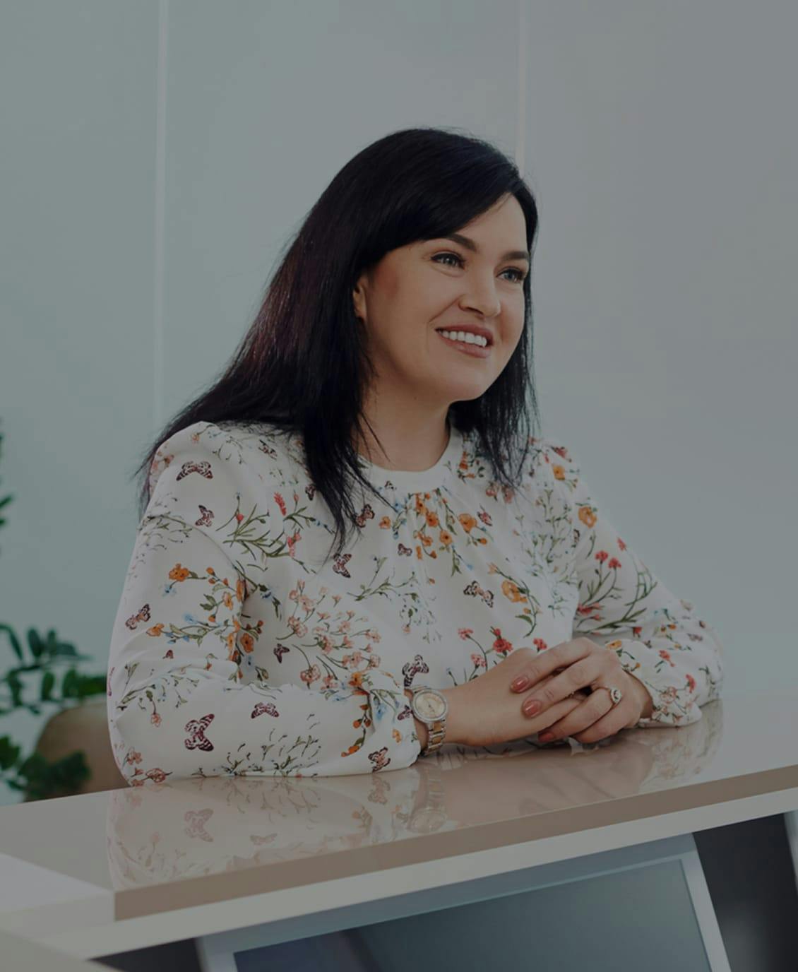 Woman sitting at a table and smiling