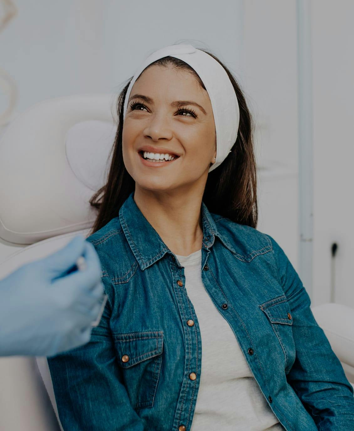 female patient wearing a white headband and jean jacket