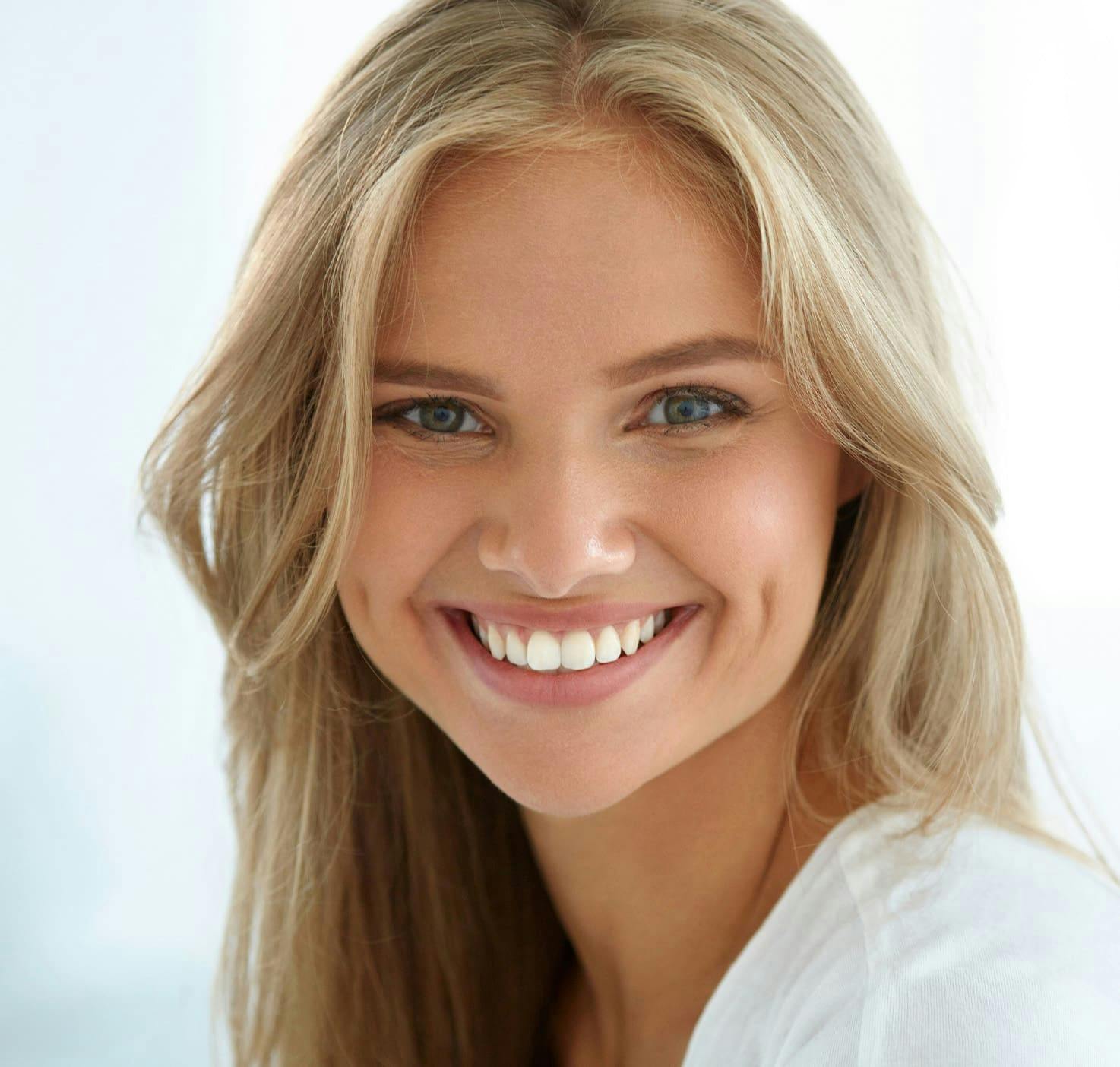 blond haired woman with big smile showing white teeth