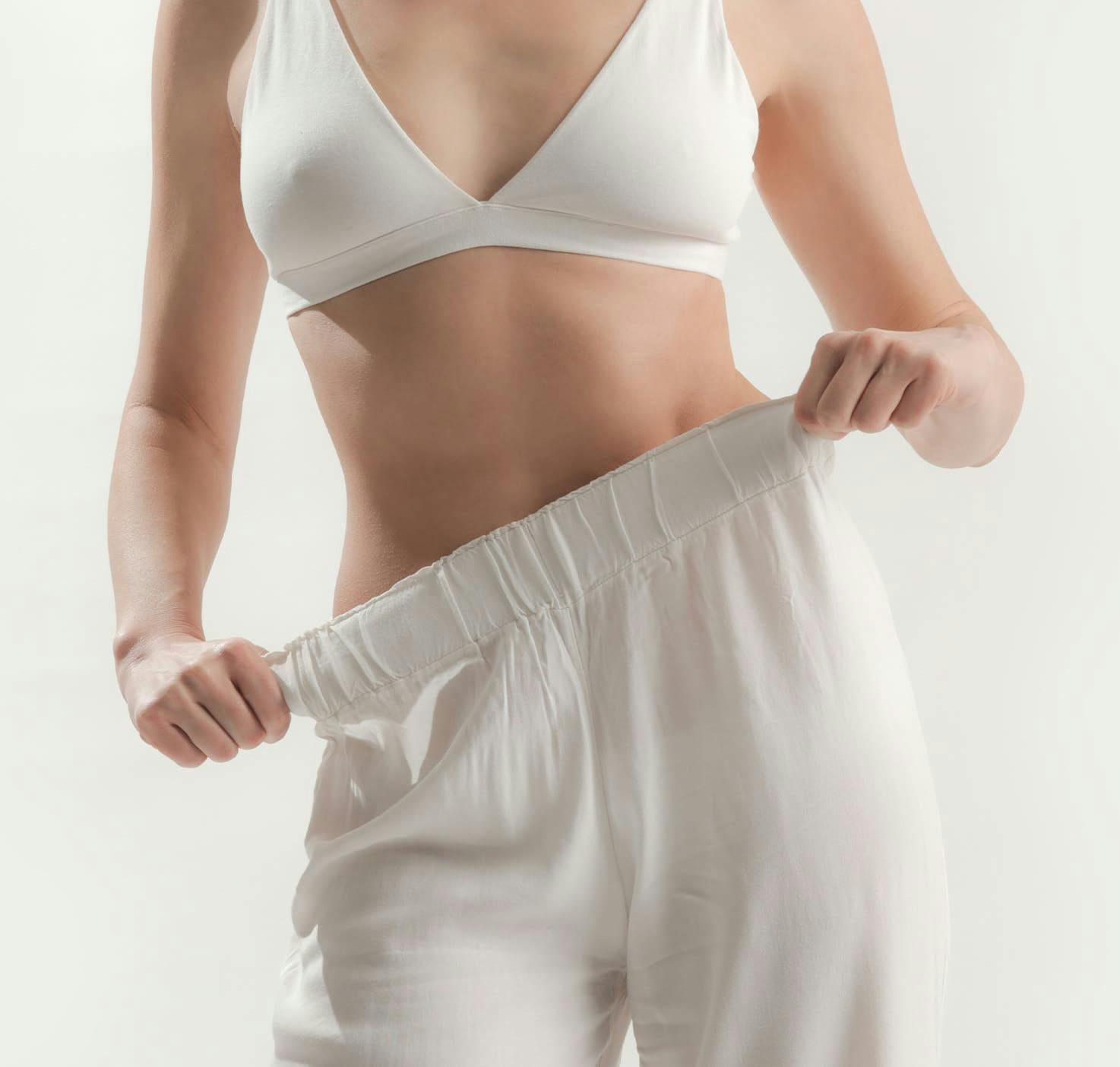 Woman wearing loose fitting pants and pulling the slack