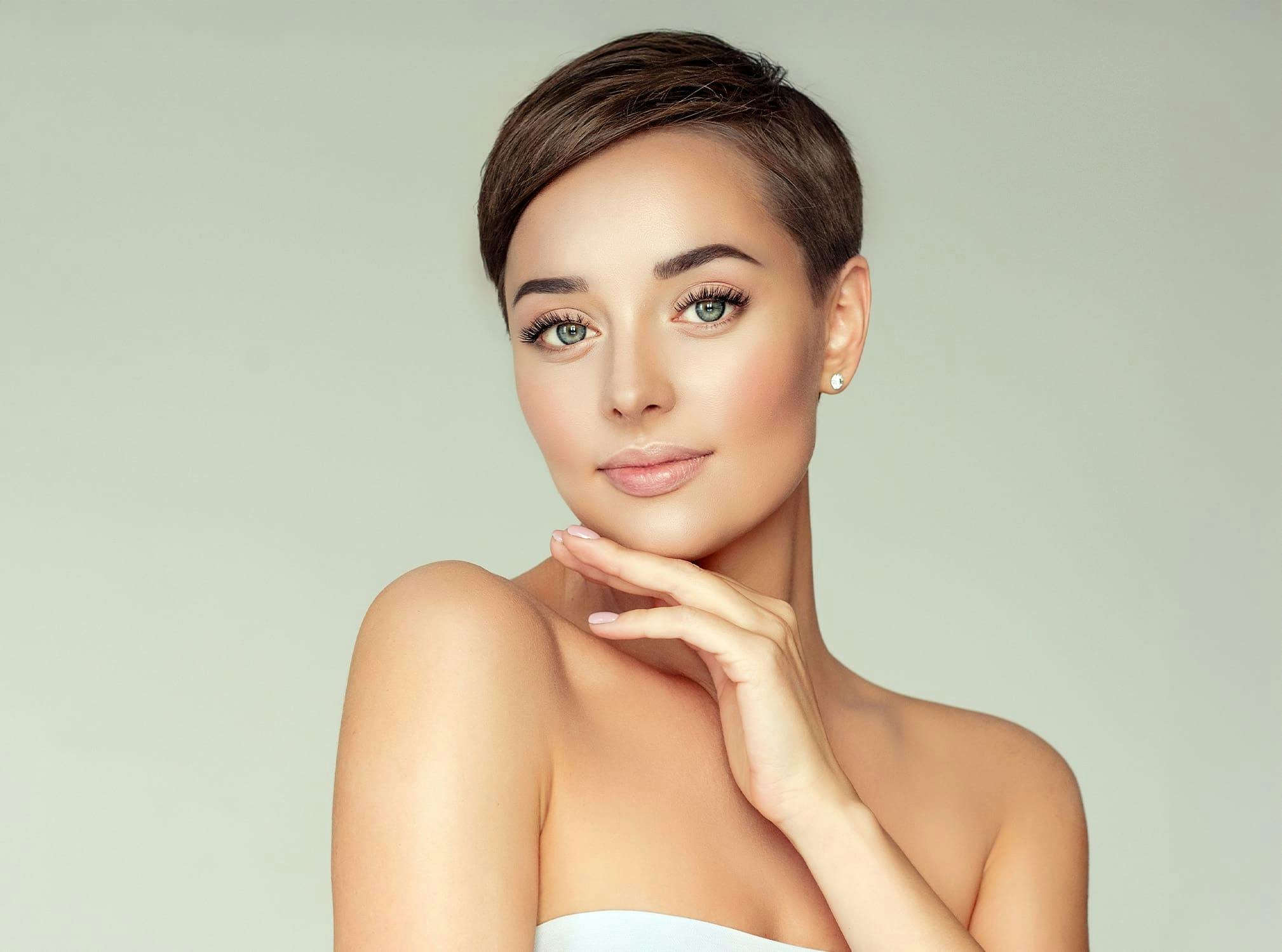 short haired woman resting chin on hand