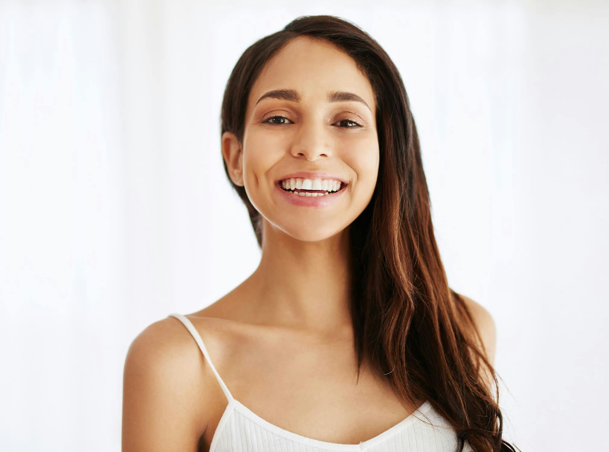 woman with white tank top smiling