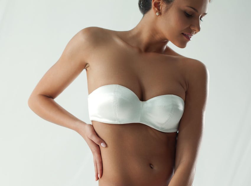 Woman in tube top with hand on hip smiling