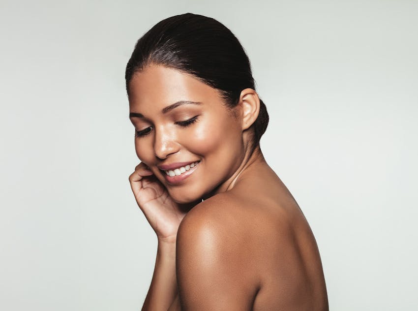 woman smiling and touching the side of her face