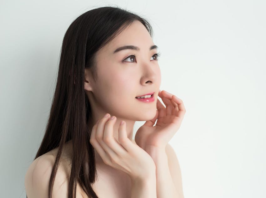 Asian woman touching chin and looking up