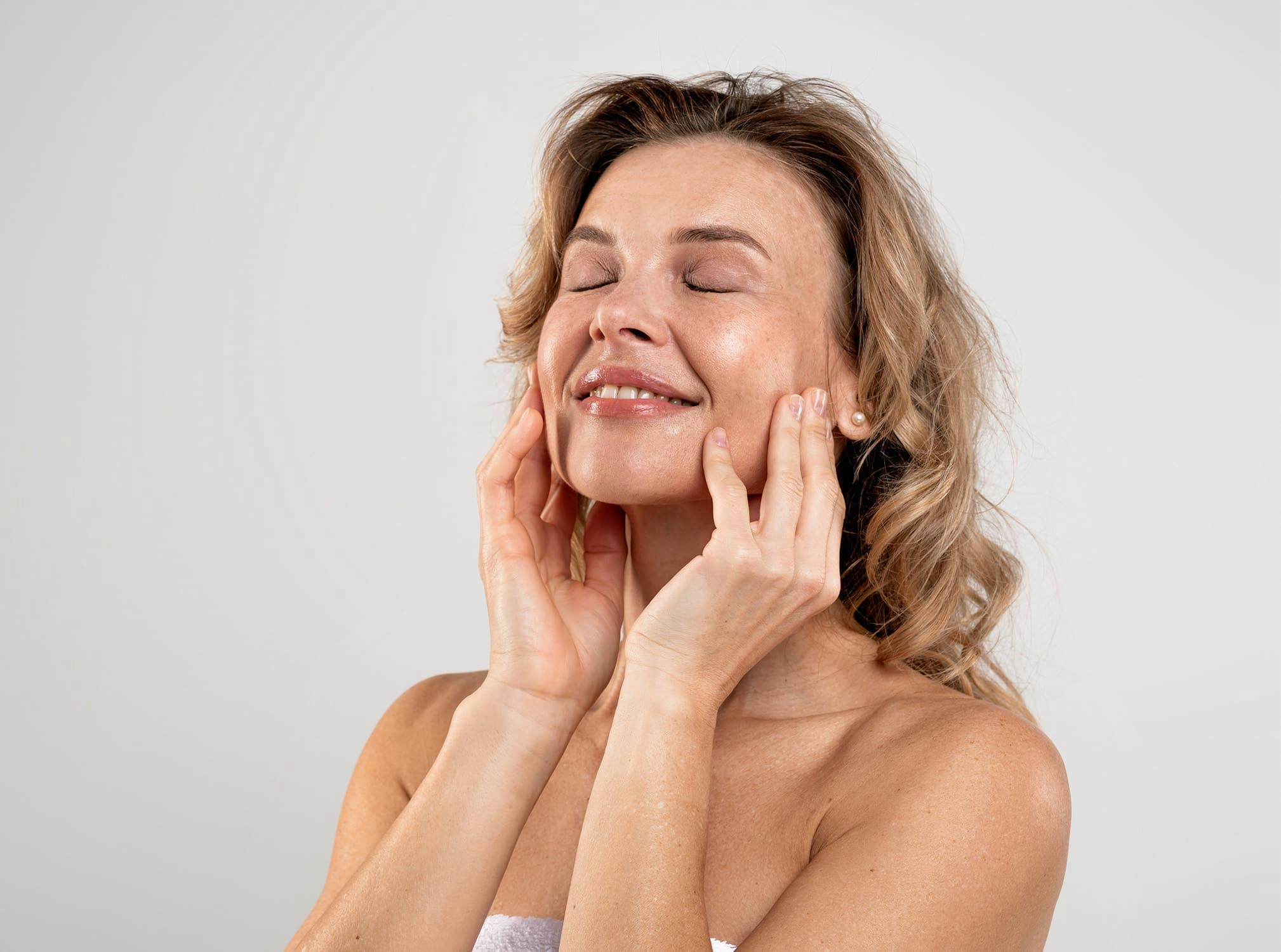 Woman smiling while touching her face