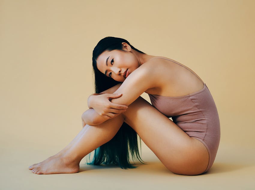 Woman sitting and holding knees