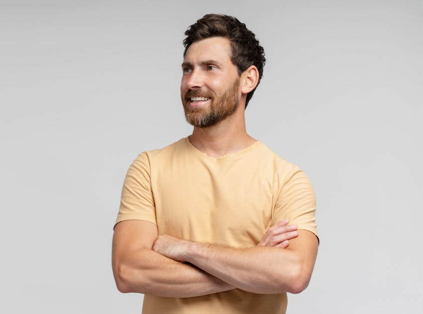 Man with arms crossed smiling