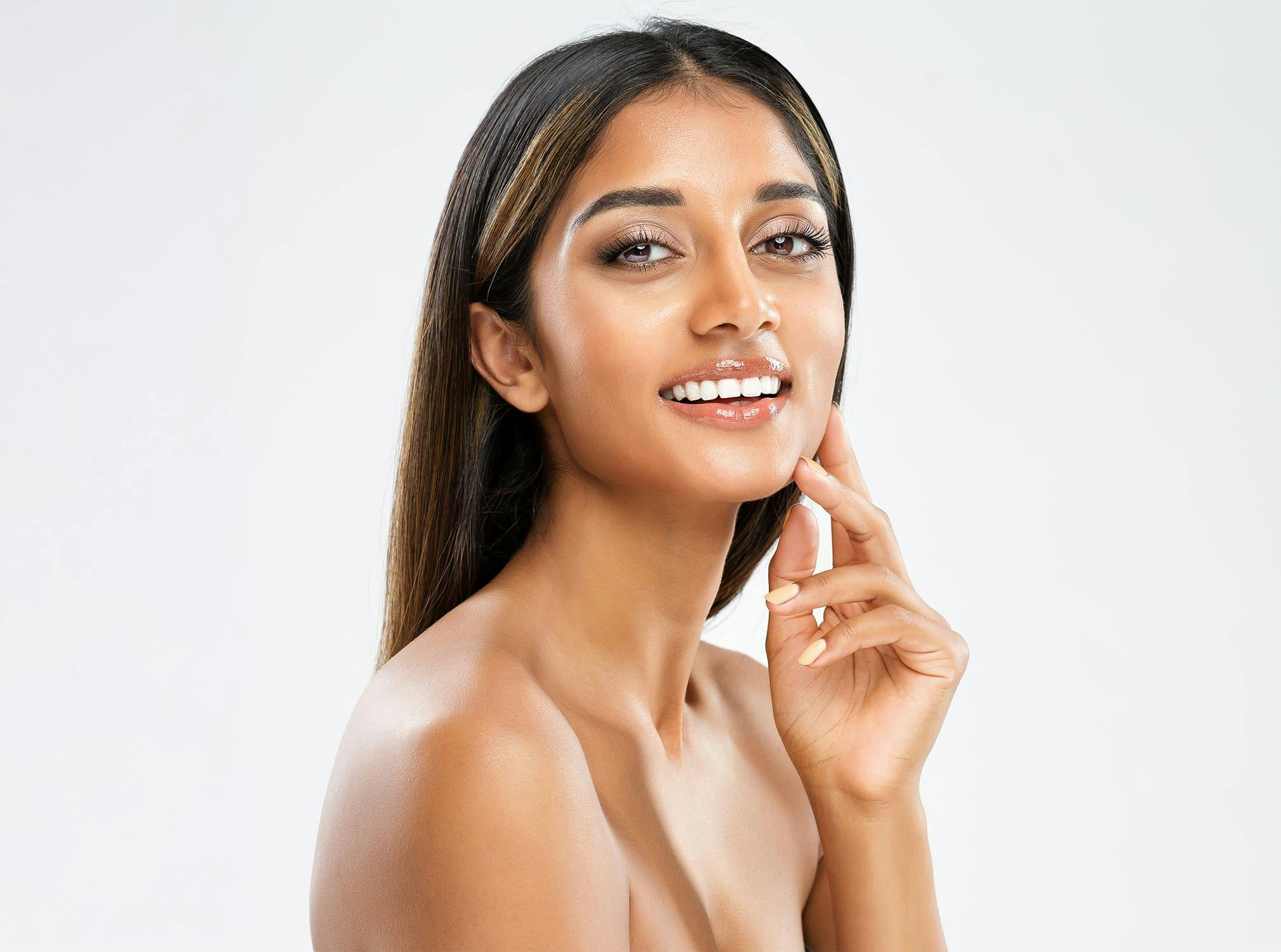 Woman smiling and touching her face