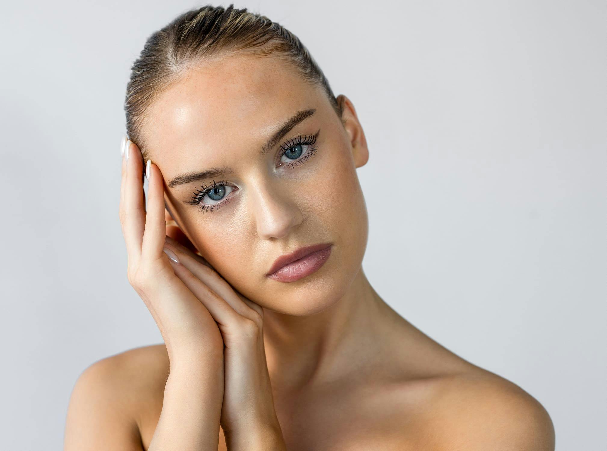 Woman with hands touching side of head