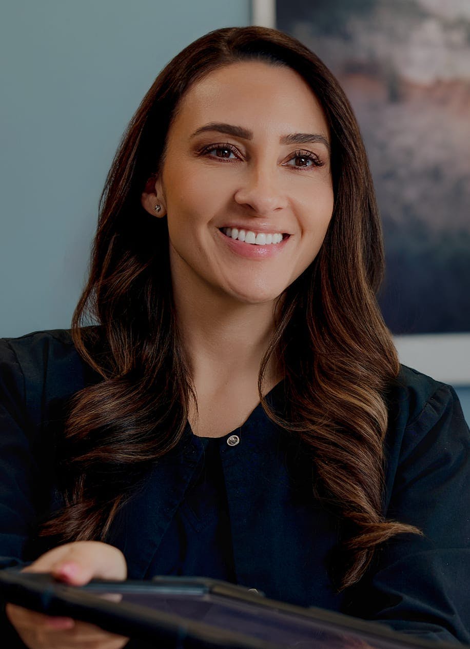 woman with brown curly hair handing someone a tablet