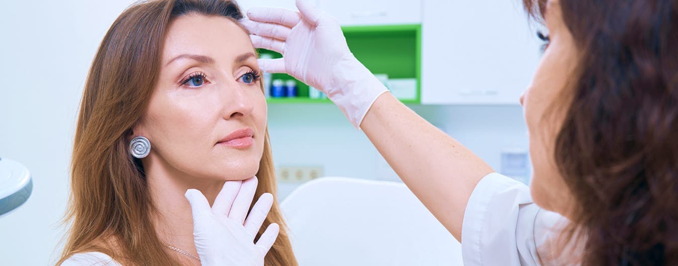 doctor looking at a female patients face