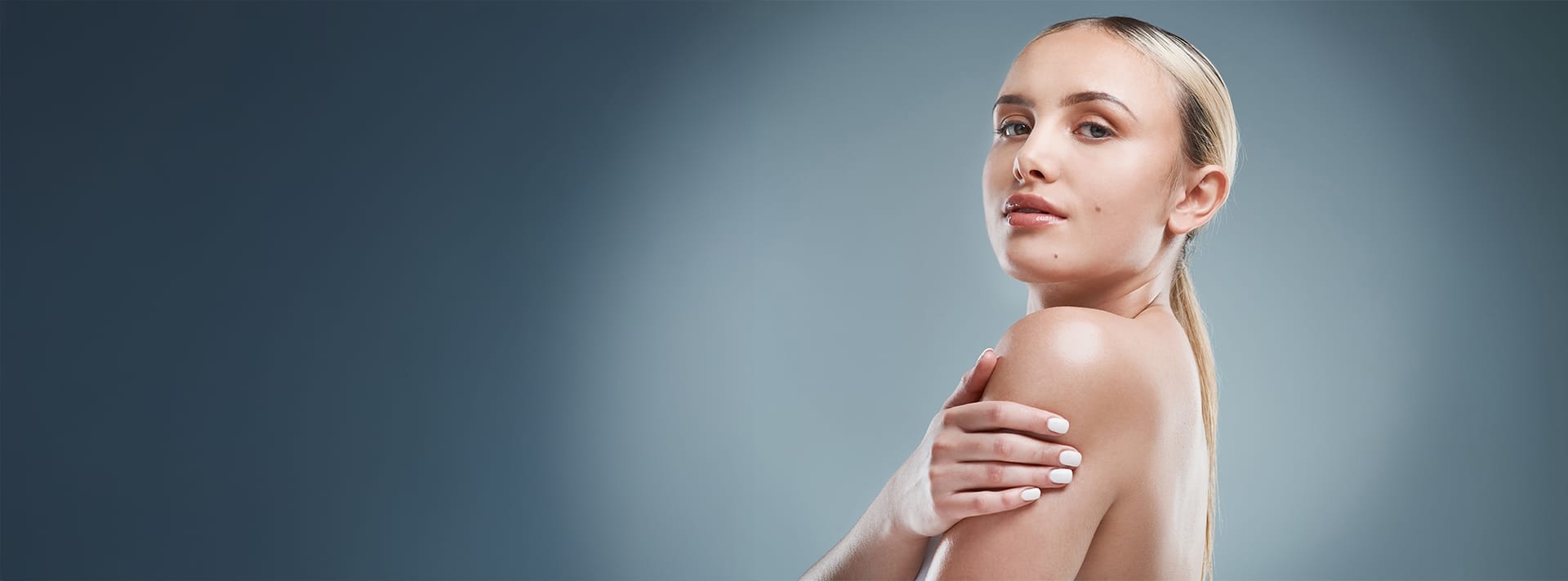 woman looking over her shoulder and holding her bicep
