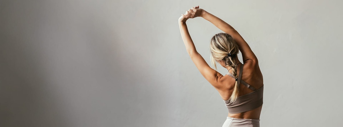 woman stretching with her arms raised