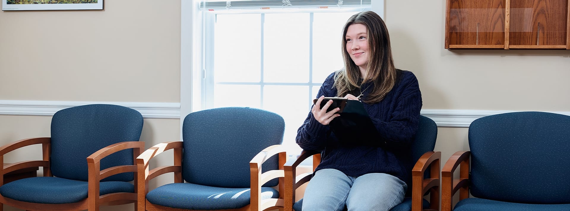 woman filling out paperwork in a waiting room