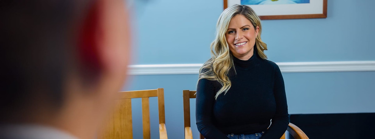 woman sitting down and smiling