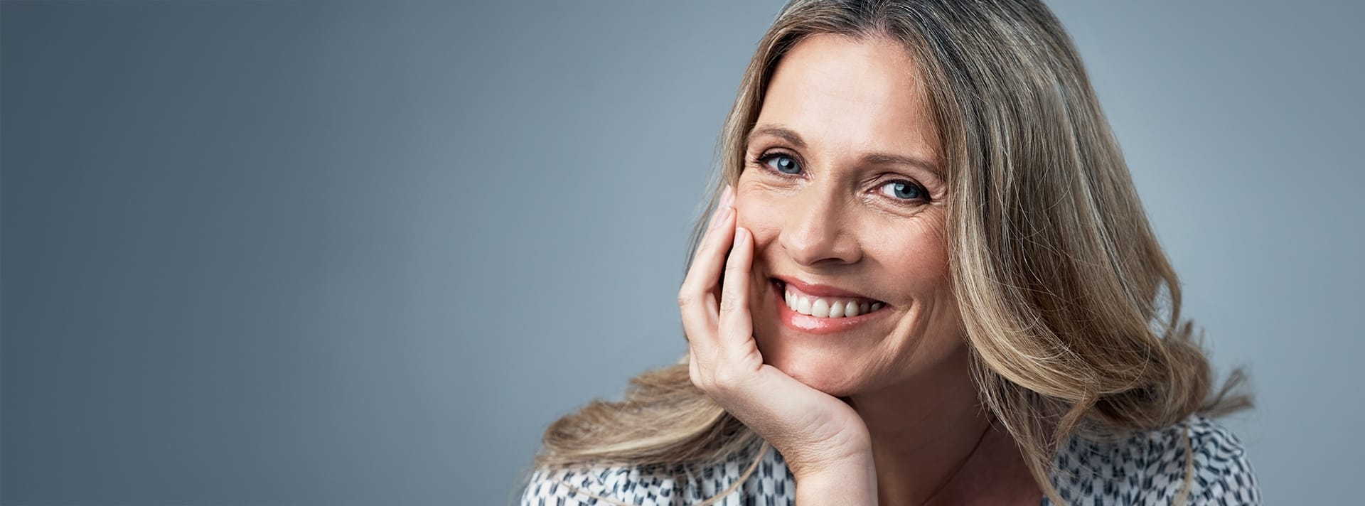 Woman smiling with chin on hand