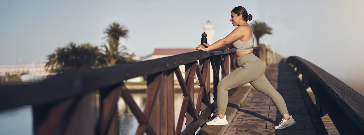 woman stretching on a bridge