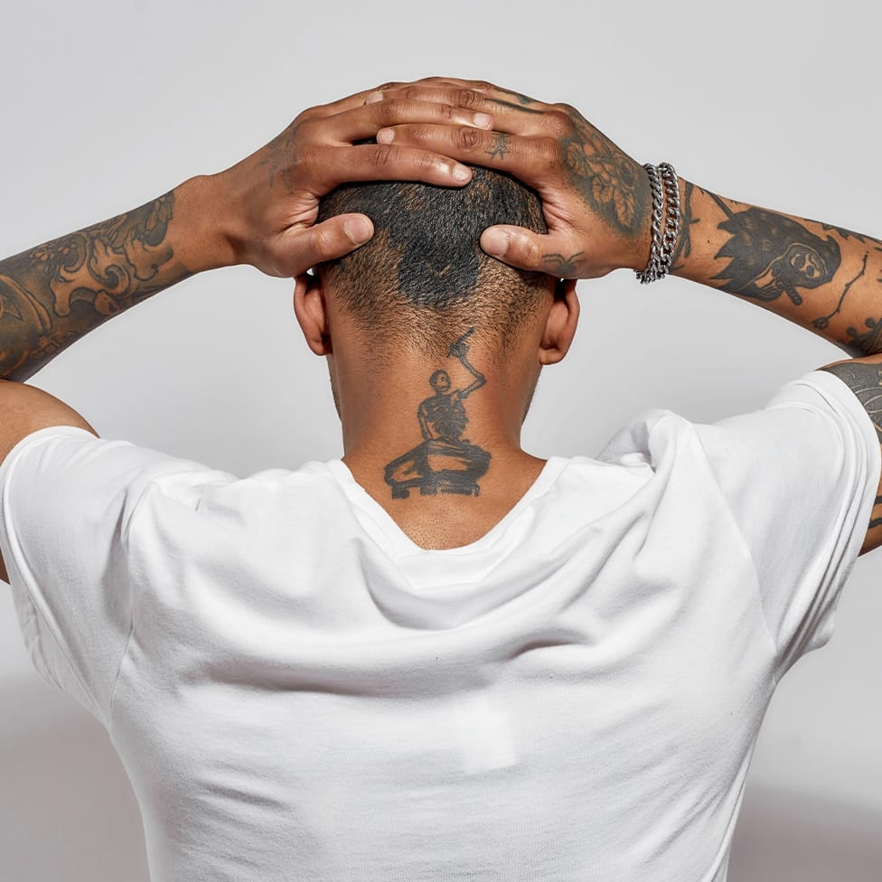 man back facing with his hands on his head