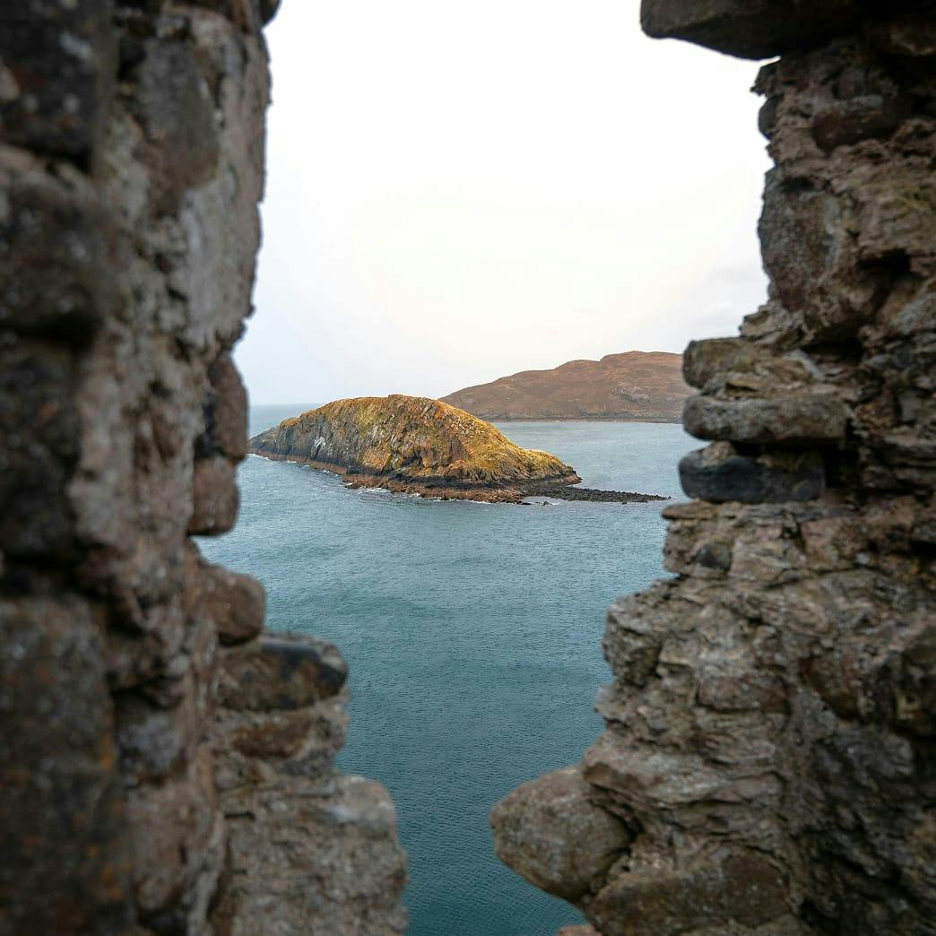 looking towards small island from in between rocky walls