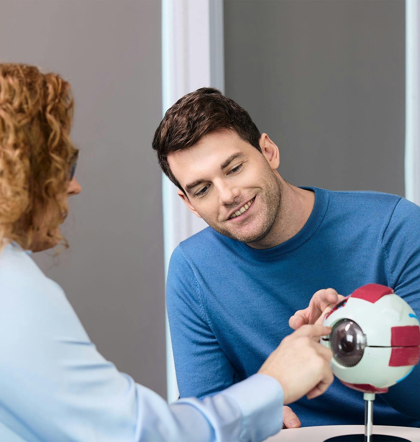 doctor showing a patient a 3D eye diagram