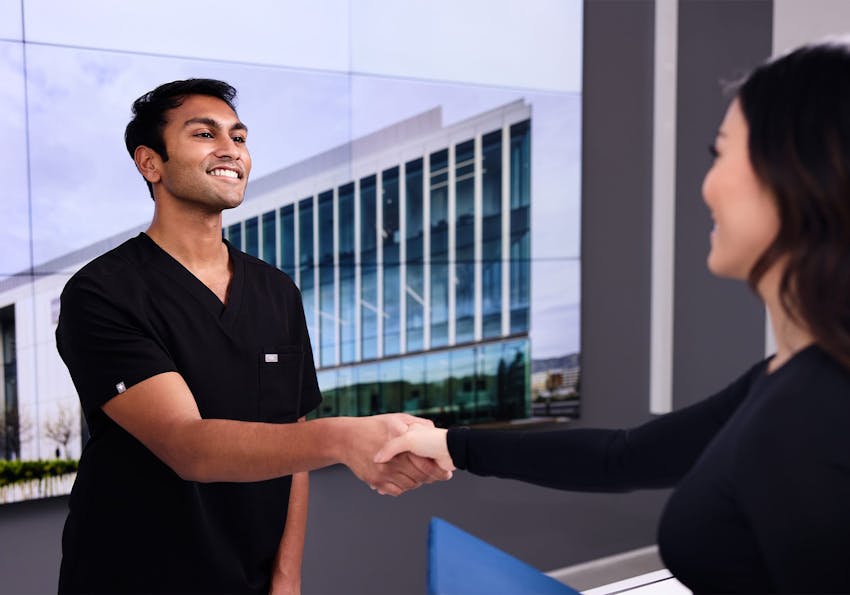 receptionist shaking hands with a patient