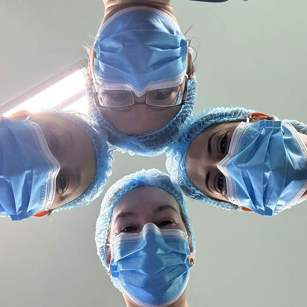 four doctors with their heads together