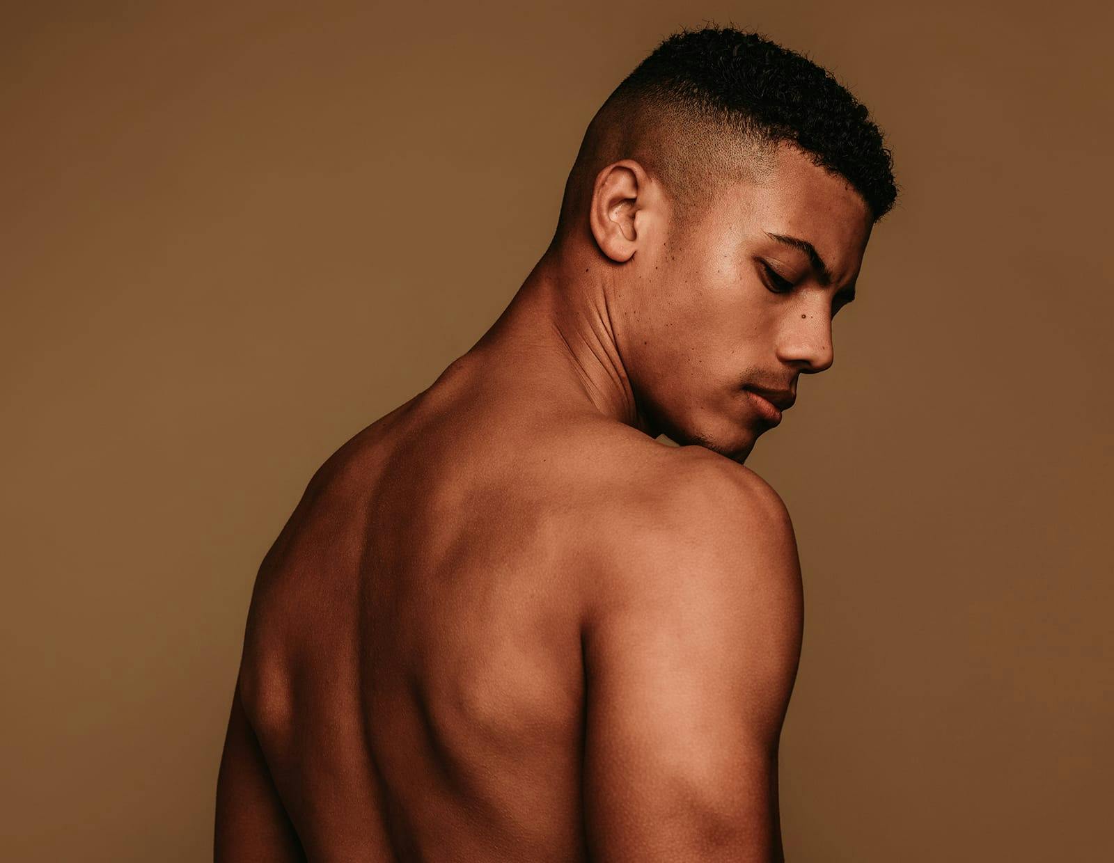 Man with a muscular back turning his head