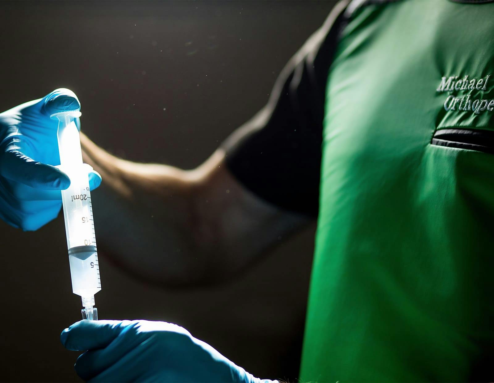 Medical professional wearing gloves preparing a syringe