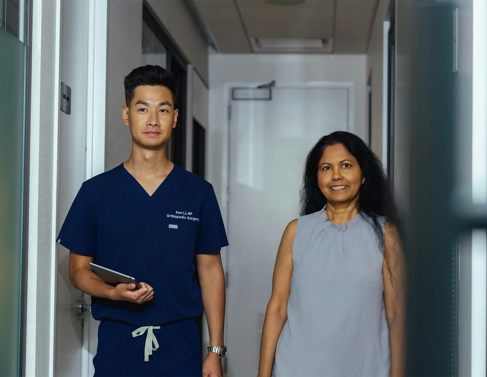 Medical professional and patient walking in a hallway