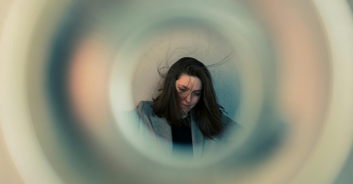 person with messy hair, spacing out inside a circle, showing signs of brain fog
