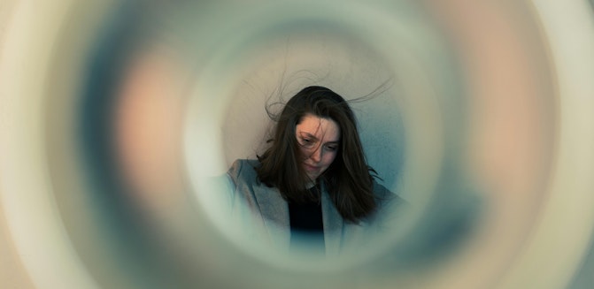 person with messy hair, spacing out inside a circle, showing signs of brain fog