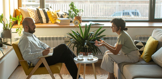 Person speaking with a psychologist or psychiatrist in professional office setting