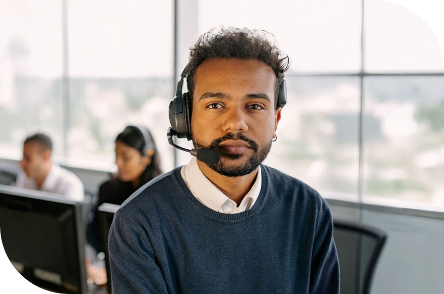 A person in an office wearing a headset, ready to assist callers on a helpline