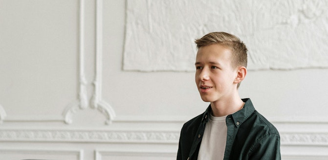 A young person sitting in a therapist’s office, looking uncertain or hesitant during a therapy session.