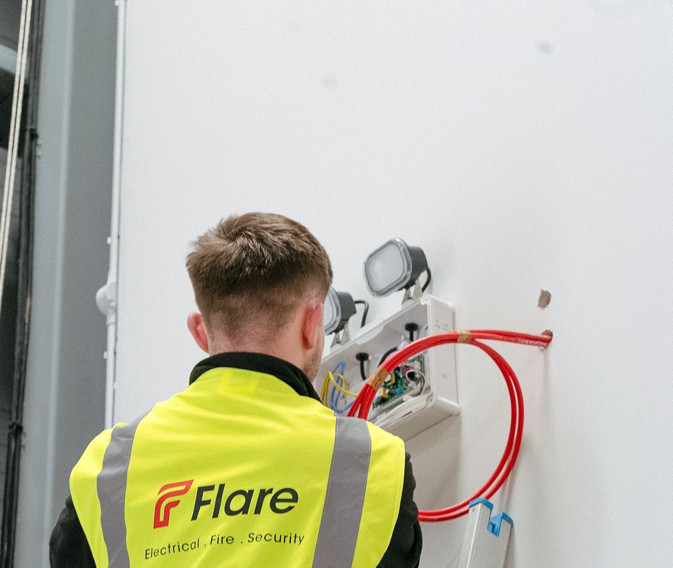 Flare EFS engineer wiring an emergency light with FP200 cable during a commercial electrical installation