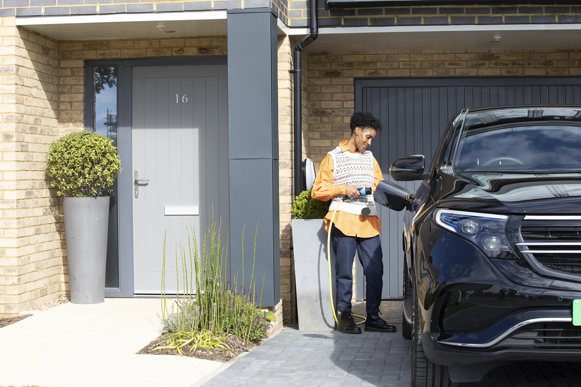 person plugs electric vehicle in