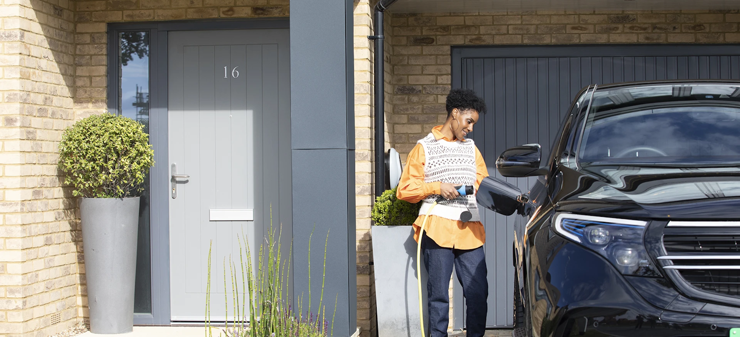 person plugs electric vehicle in