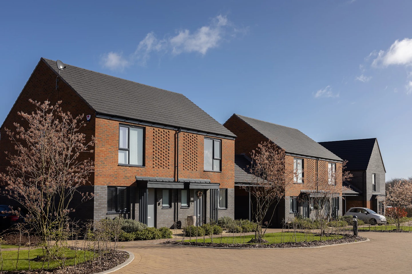 A row of starter homes aimed at first time buyers. The ground floor uses black bricks while the first floor use brown bricks.
