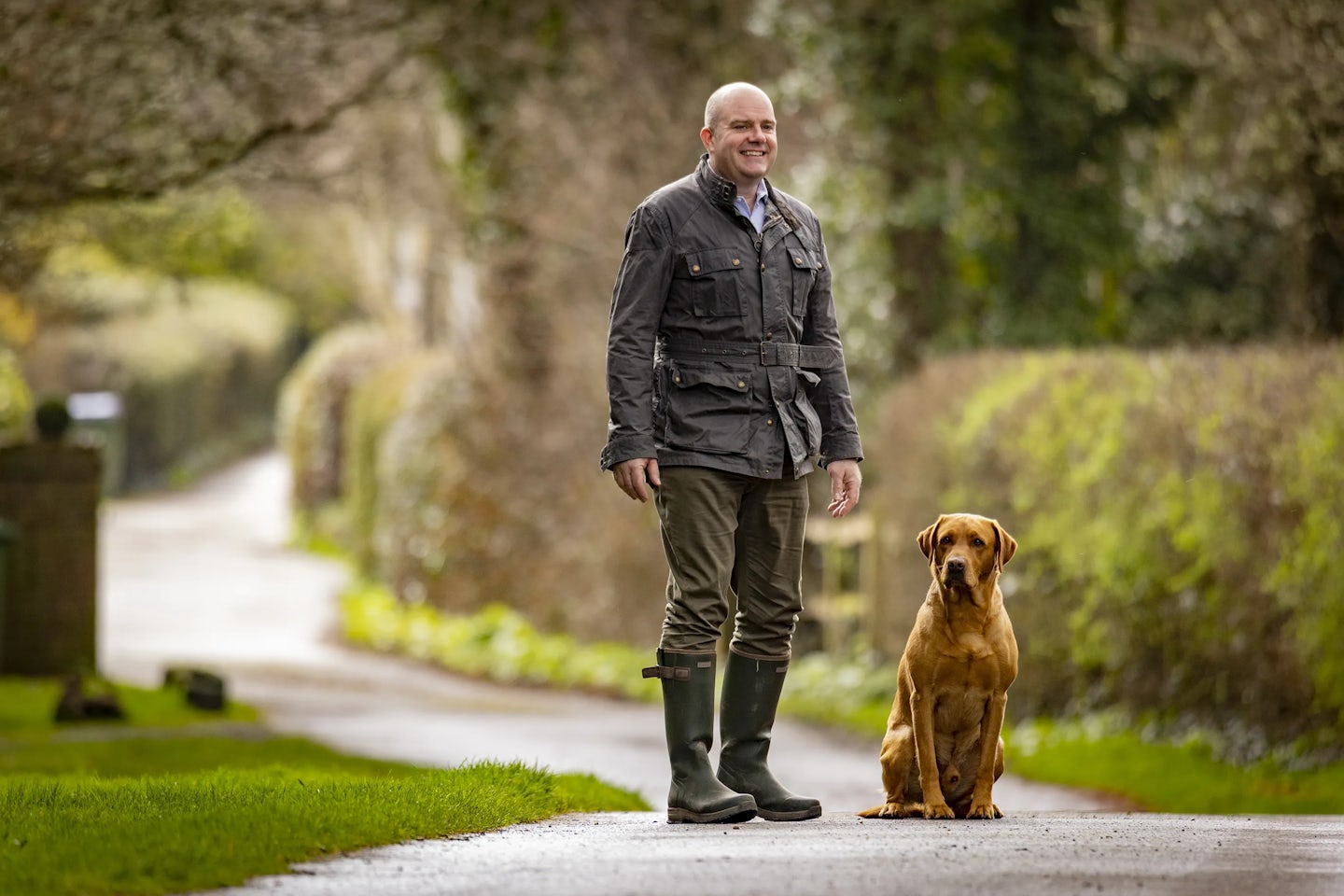 Thakeham CEO Rob Boughton walks along a paved path with a dark gold dog.