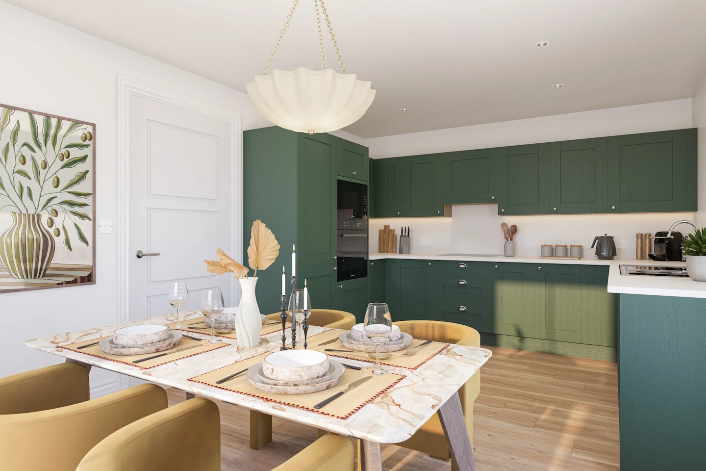 A modern kitchen and dining area featuring sage green cabinets, a black oven, and sleek countertop appliances including a kettle and coffee maker. The dining table, made of white marble, is elegantly set with minimalist plates, glasses, and cutlery. At its centre, a white vase with dried foliage and two candlesticks add a natural, decorative touch. Above hangs a sculptural pendant light. The space is finished with warm wood flooring and a white wall displaying botanical artwork.