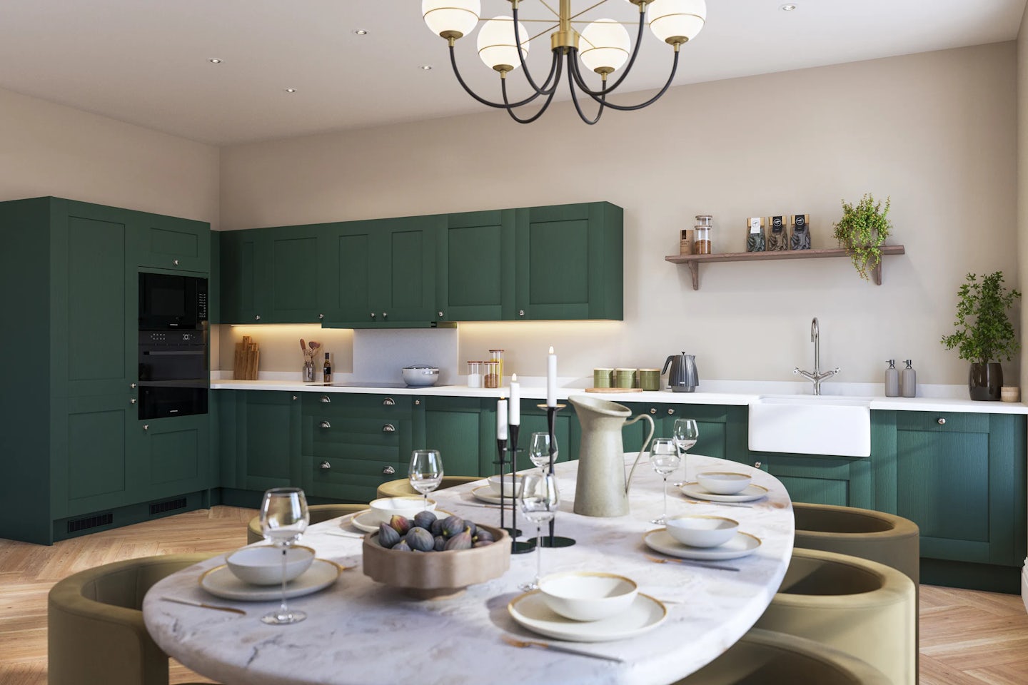 Modern kitchen interior with green cabinetry and a marble-topped dining table. The space features a farmhouse sink beneath an open shelf lined with jars and a plant, along with built-in appliances and contemporary lighting including a chandelier. The dining table is set with dinnerware, glasses, and a decorative centerpiece of candles and ornaments, creating a warm and elegant atmosphere.