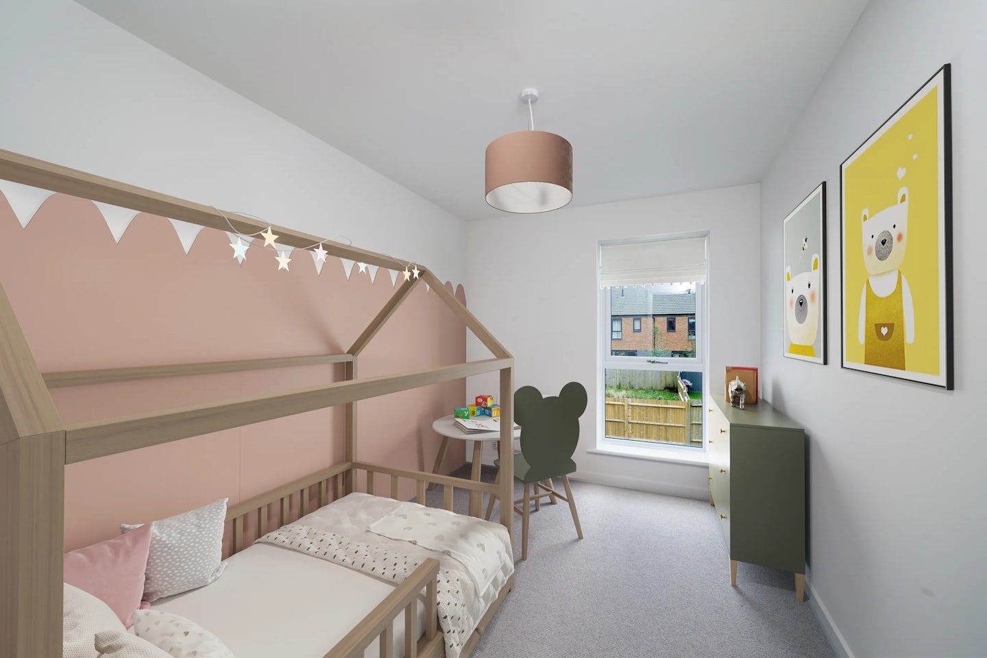 A children’s bedroom featuring a wooden house-shaped bed against a soft pink accent wall, adorned with hanging star-shaped lights. A green chair with Mickey Mouse ears sits beside a small table near a sunlit window. A green dresser with toys on top stands nearby, and two framed bear illustrations hang on the wall. The room feels playful, tidy, and welcoming, designed with a child’s comfort and imagination in mind.