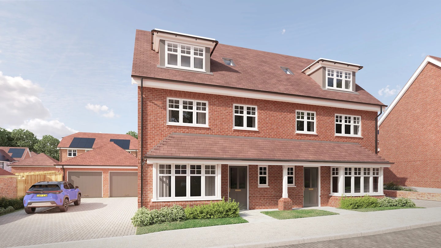A CGI of a semi-detached, three-storey brick house with a red-tiled roof and dormer windows, located in a suburban neighbourhood. Each unit has a separate front door, large ground-floor windows, and a small landscaped garden with shrubs. A blue car is parked on the driveway beside a detached garage, under a clear, lightly clouded sky.