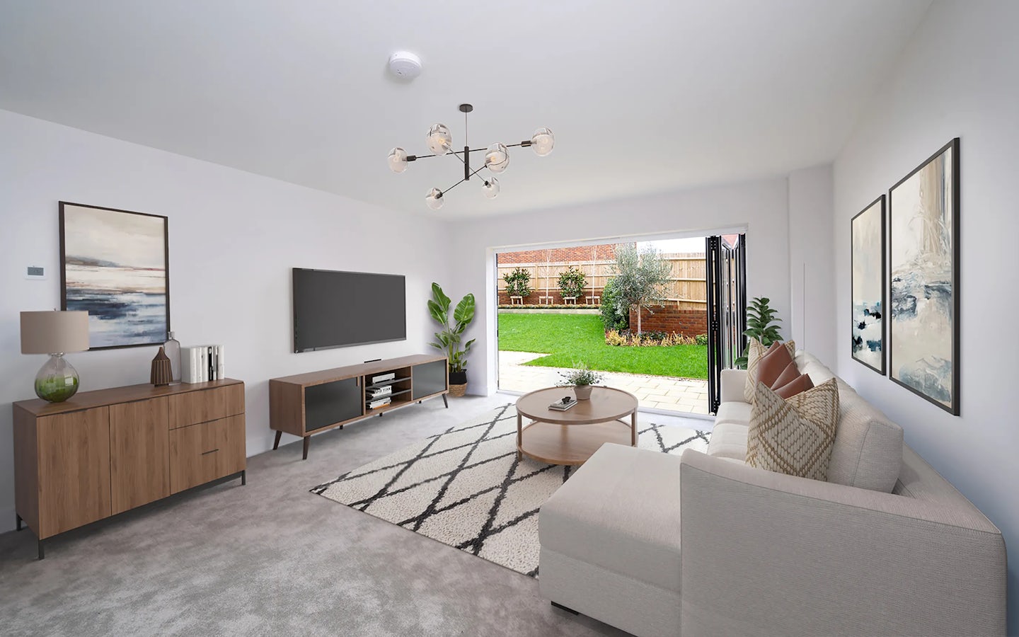 Modern living room with a white sectional sofa, light grey carpet, and wooden furniture, including a coffee table, sideboard, and TV stand. Abstract artwork and potted plants decorate the space, while a large sliding glass door opens to a green backyard with a patio.