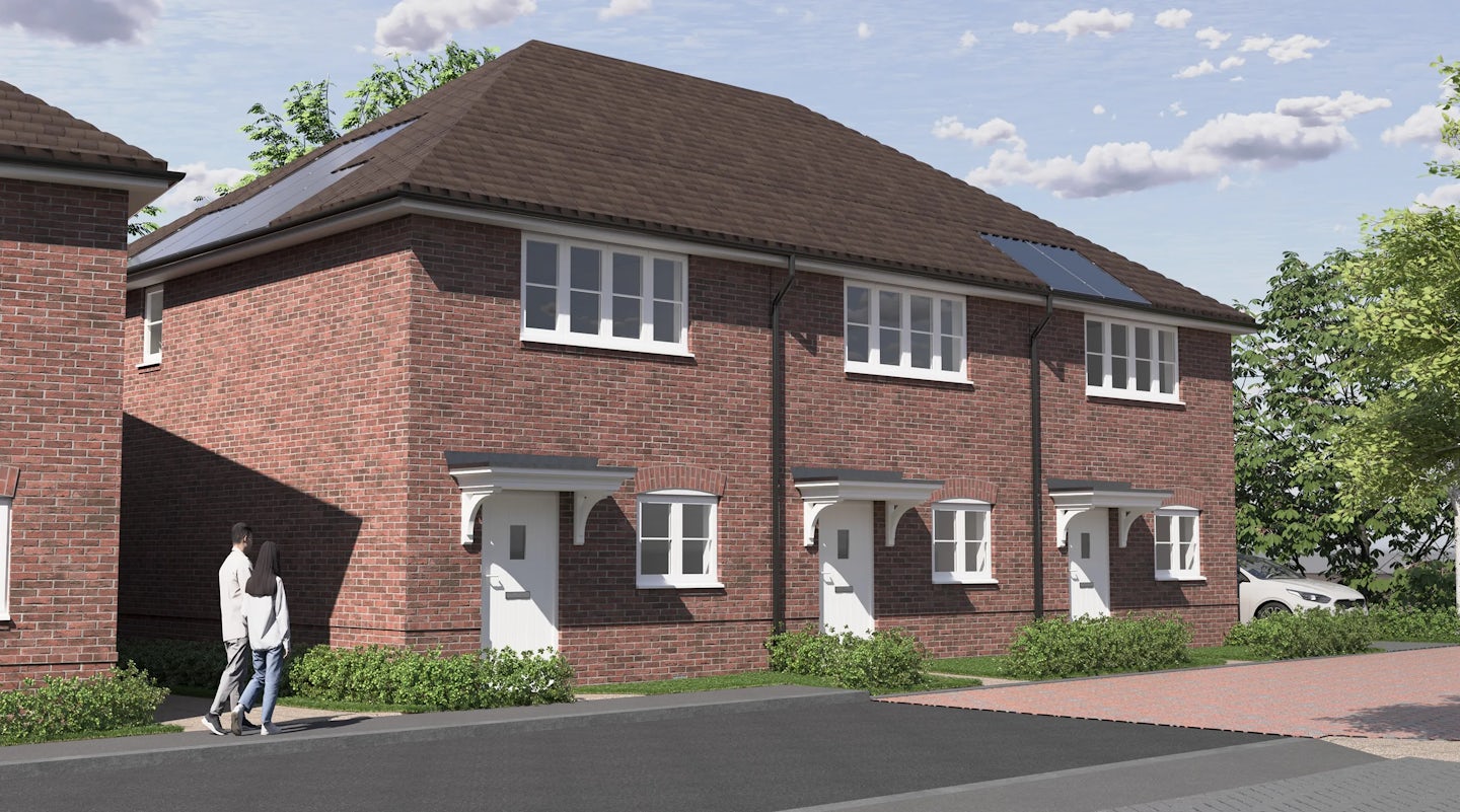 CGI of a Row of brick townhouses with white doors, canopies, and white-framed windows, set along a landscaped residential street. Solar panels are visible on the roof of the right-hand home, emphasizing energy efficiency. Green bushes and trees line the sidewalk, where two people walk past, adding a sense of community to the tranquil, eco-conscious setting.