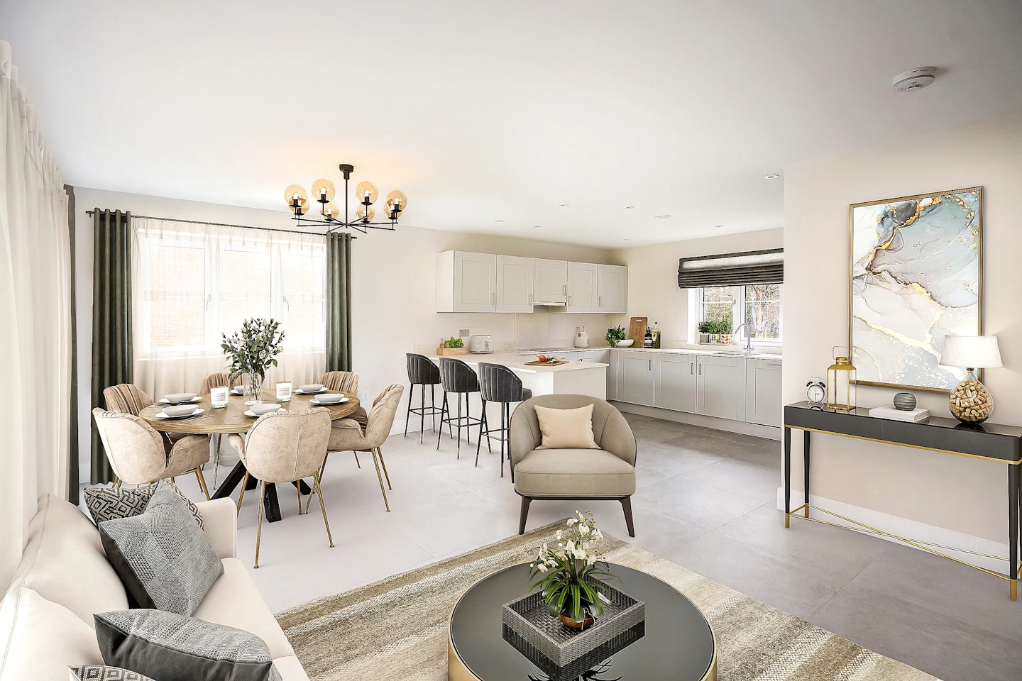 Spacious open-plan living and dining area with a modern kitchen backdrop. The living space features a white sofa with grey cushions, a beige armchair, and a round coffee table with a green plant centerpiece. Adjacent, the dining area includes a round table set for four, surrounded by beige upholstered chairs and lit by a contemporary chandelier. The kitchen showcases white cabinetry, a long countertop with decorative items, and four black bar stools aligned along the breakfast bar. A side console table displays decor including a lamp and framed abstract artwork